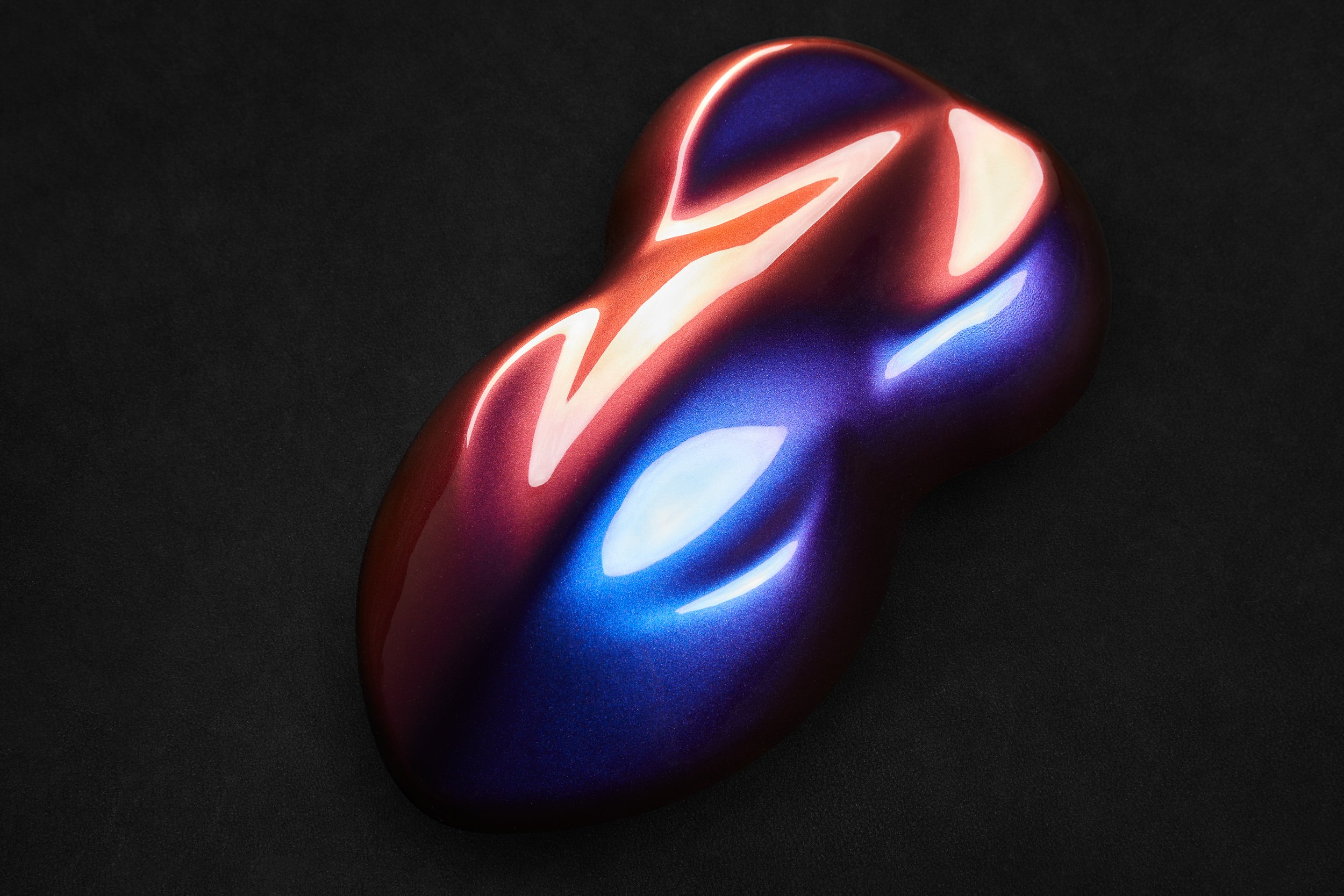 Color-shifting paint sample on black background.