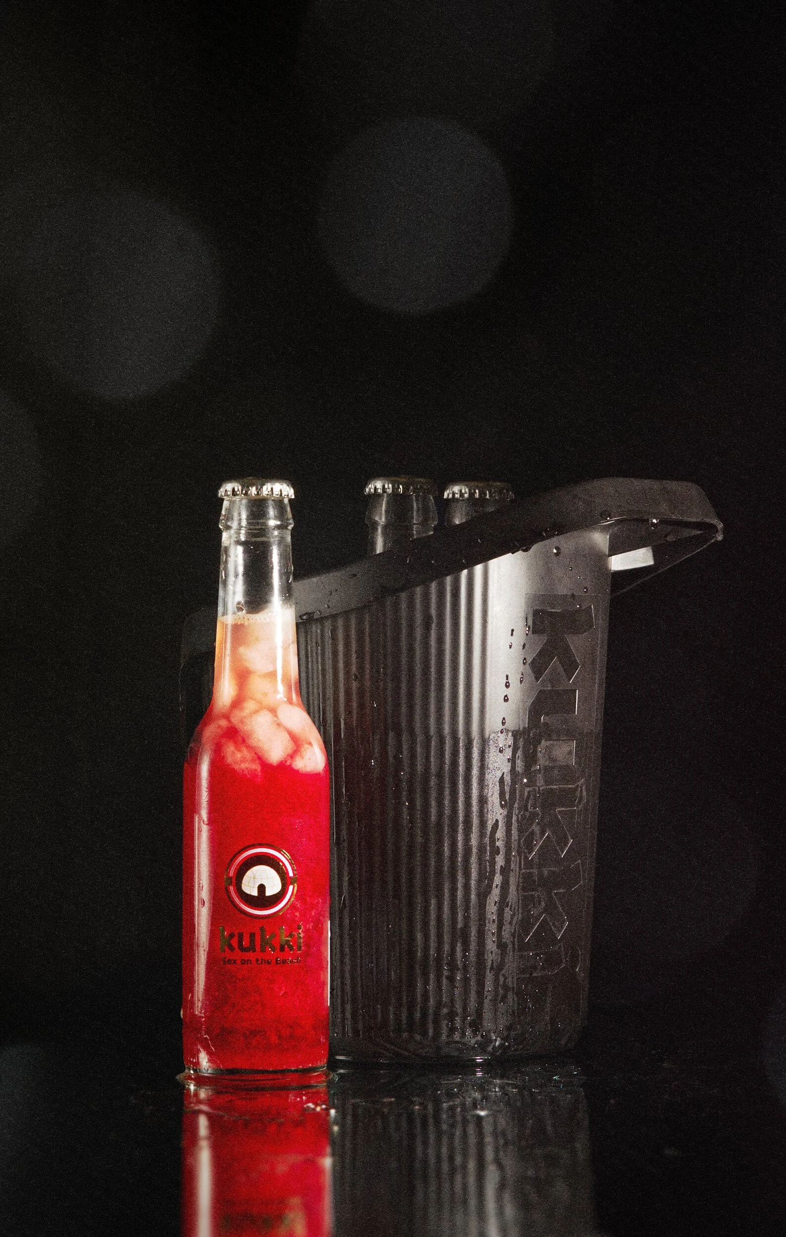 der Cocktail Auftaueimer von kukki mit einer roten Flasche von kukki.