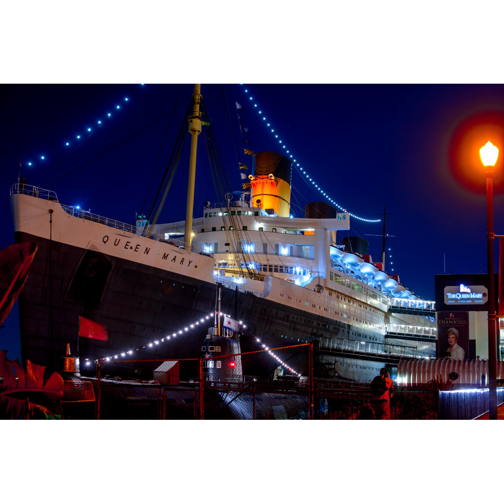 Queen Mary at Night – illuminated historic ocean liner with submarine in foreground in Long Beach California