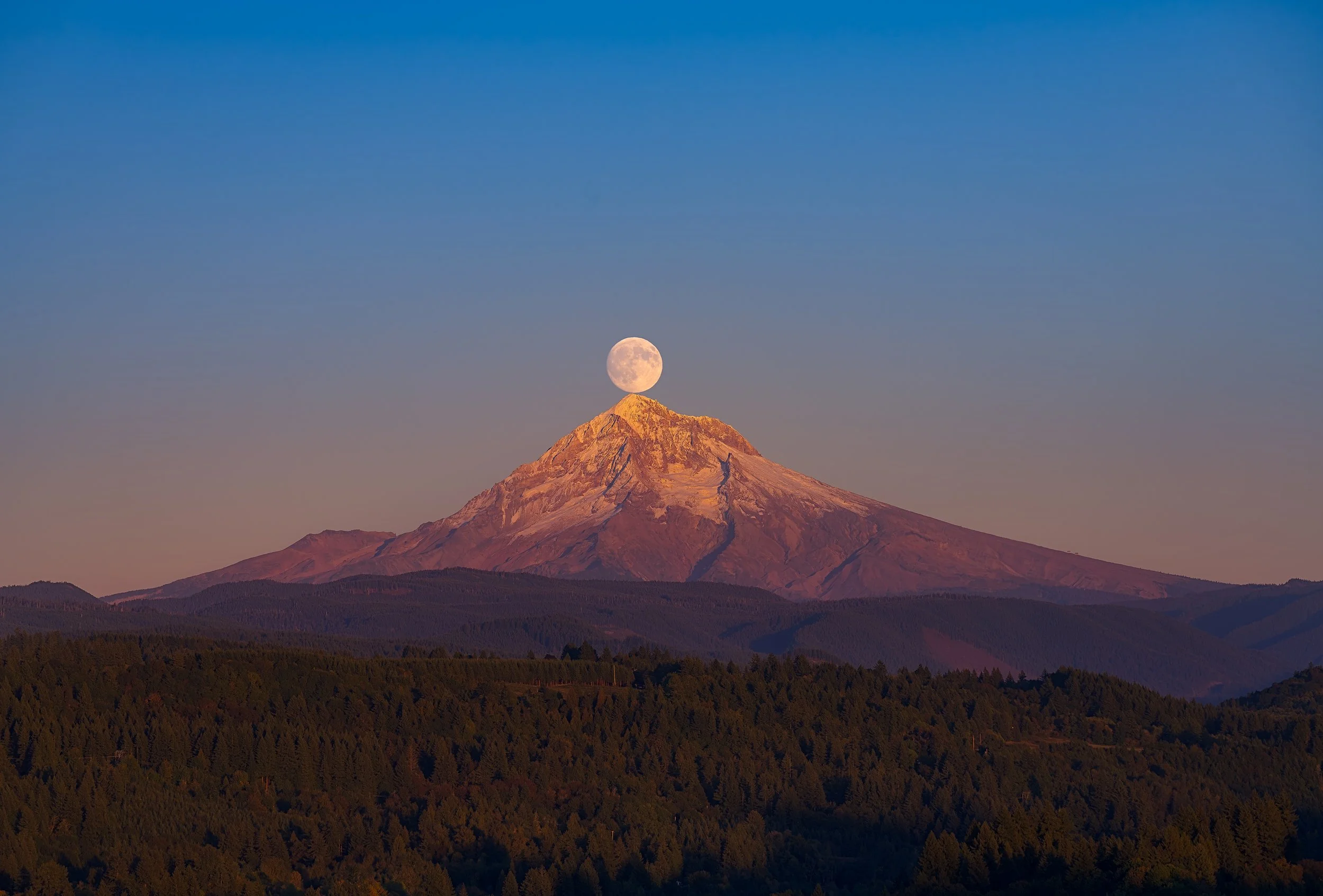 A Fine art landscape photograph of the Full Harvest Moon alignment above Mt. Hood, captured by Andrew Sambuceto.