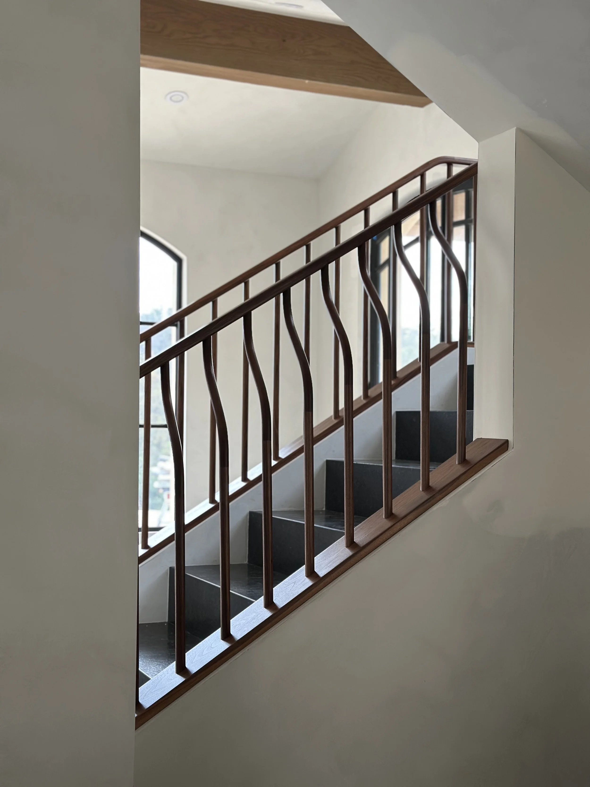 Custom sculptural walnut wood banister Hand built by Seth Jiles at Jiles Woodworks in San Diego, CA for new home in Rancho Santa Fe, CA

