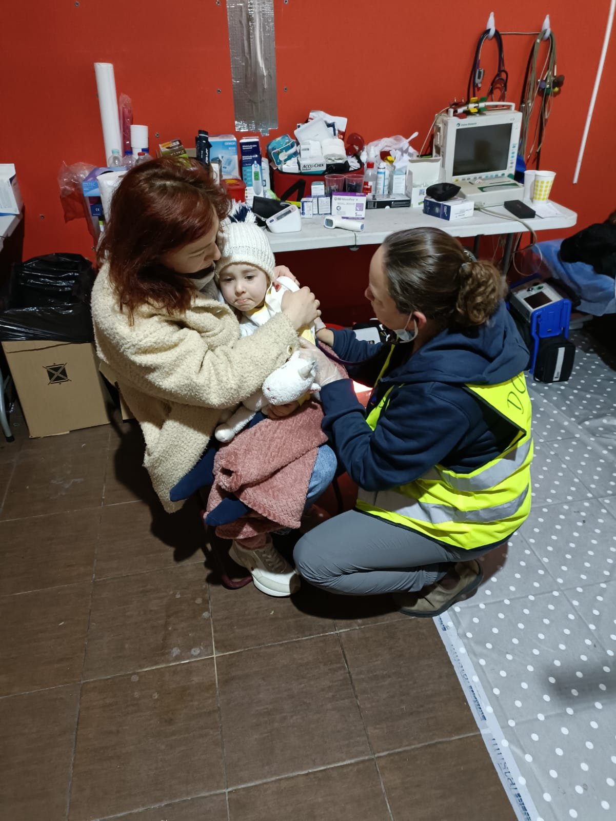 Dr Sharon Shaul helping a mother and child at the refugee center clinic