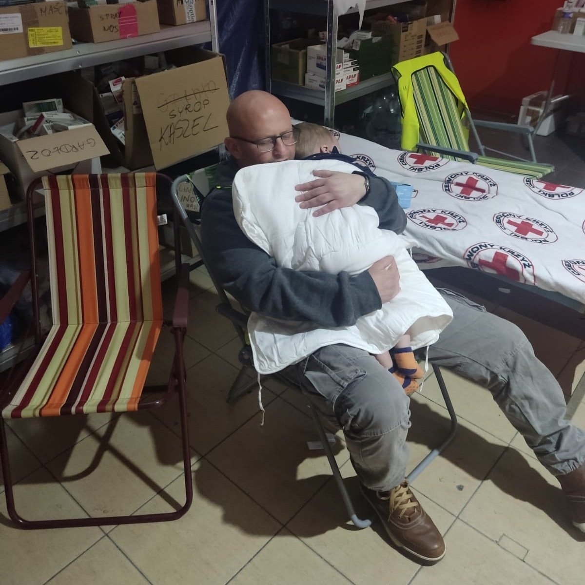 NATAN RN Alex Lubashevski comforts an infant at the refugee center clinic