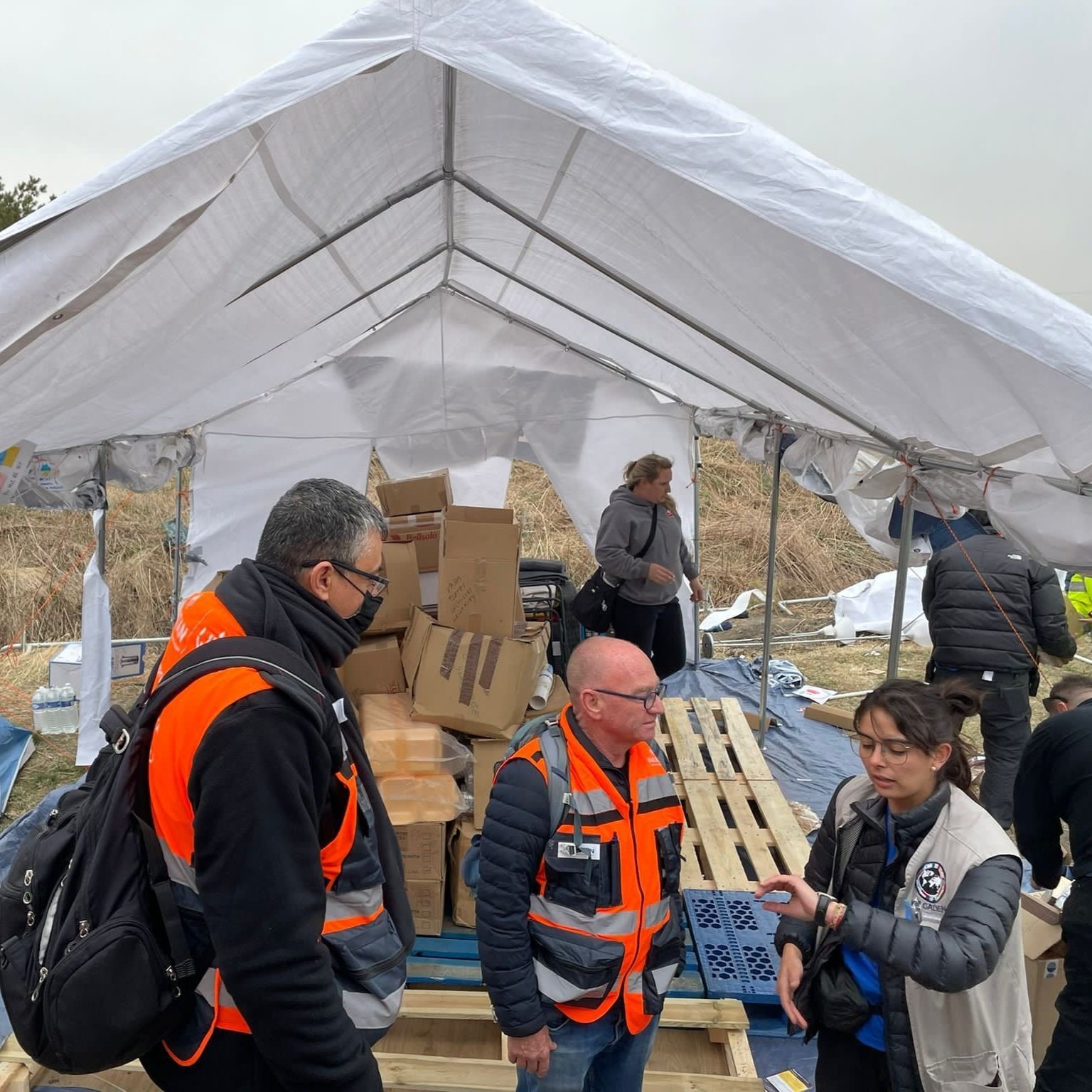 NATAN team members Menny Malka and HOM Oded Regev are briefed by Cadena volunteer at Medyka border crossing