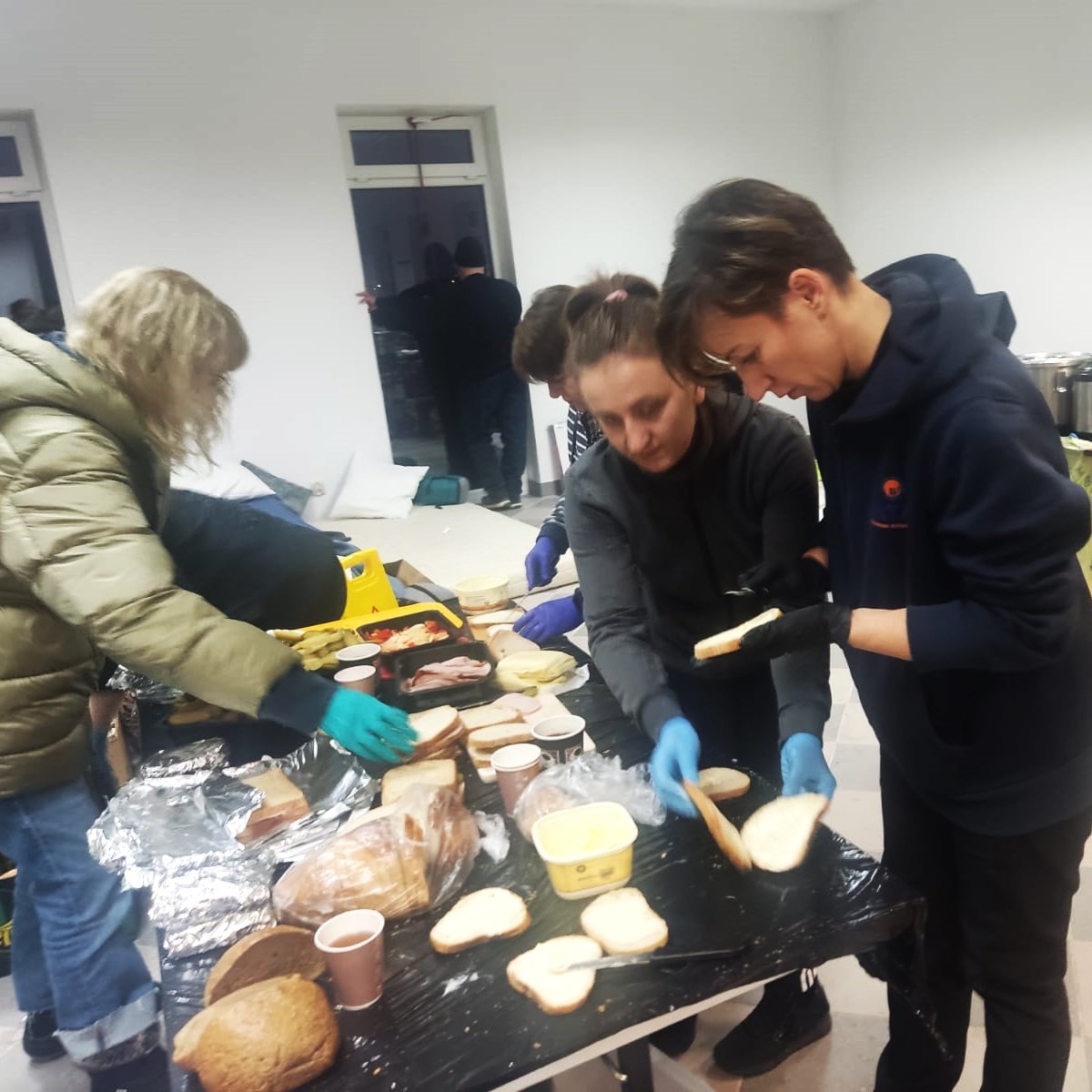 After their shift in the clinic, NATAN doctors pitch in making sandwiches for arriving refugees