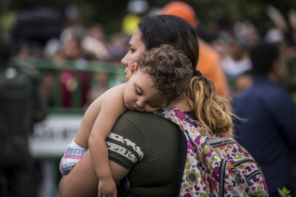 A mother holds her baby as she crosses the Simón Bolívar Bridge, Cúcuta, Colombia, April 2019. © UNHCR/Vincent Tremeau