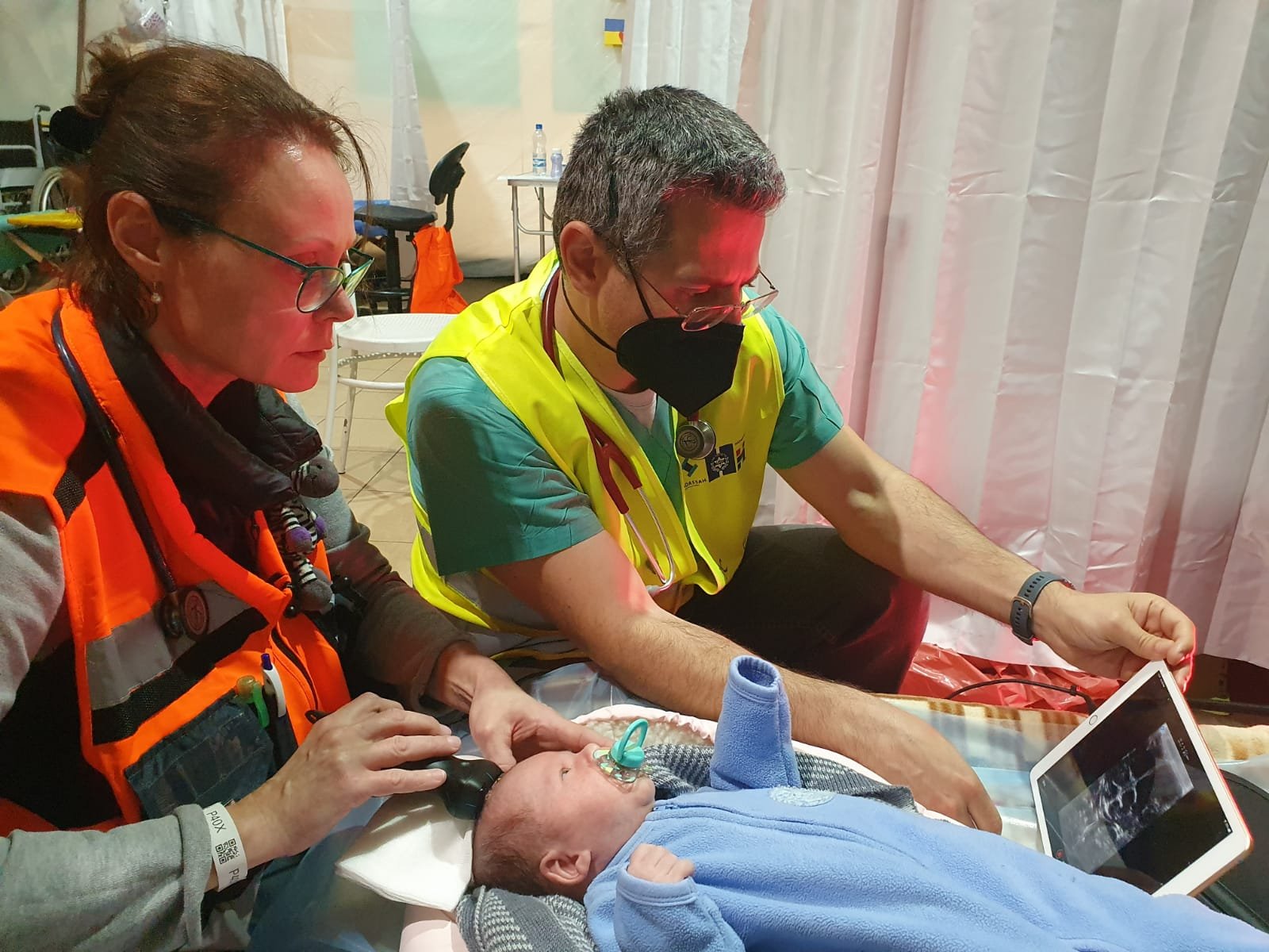 Dr. Iryna Beylin and a colleague treat an infant at the refugee center clinic