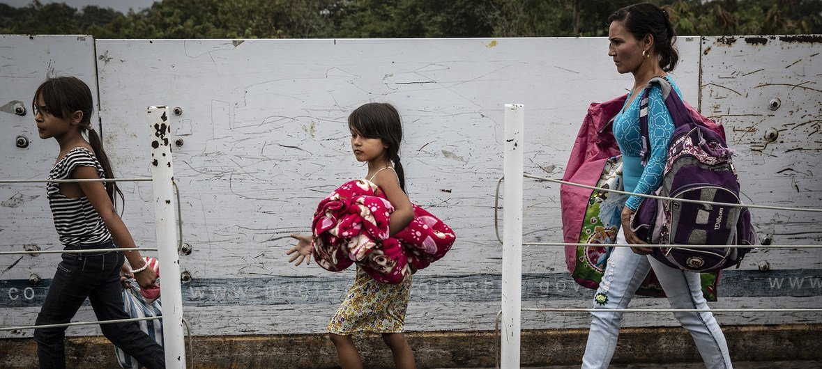 A woman and her children cross the Colombia-Venezuela border (photo source: © UNHCR)