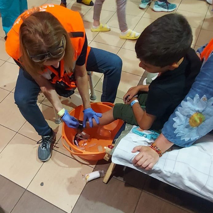 Gudrun Seligsohn treats a young boy's foot wounds at the medical clinic run by NATAN at the refugee center. Social Worker Tatiana Gur translates for a refugee inquiring about possible asylum in the UK