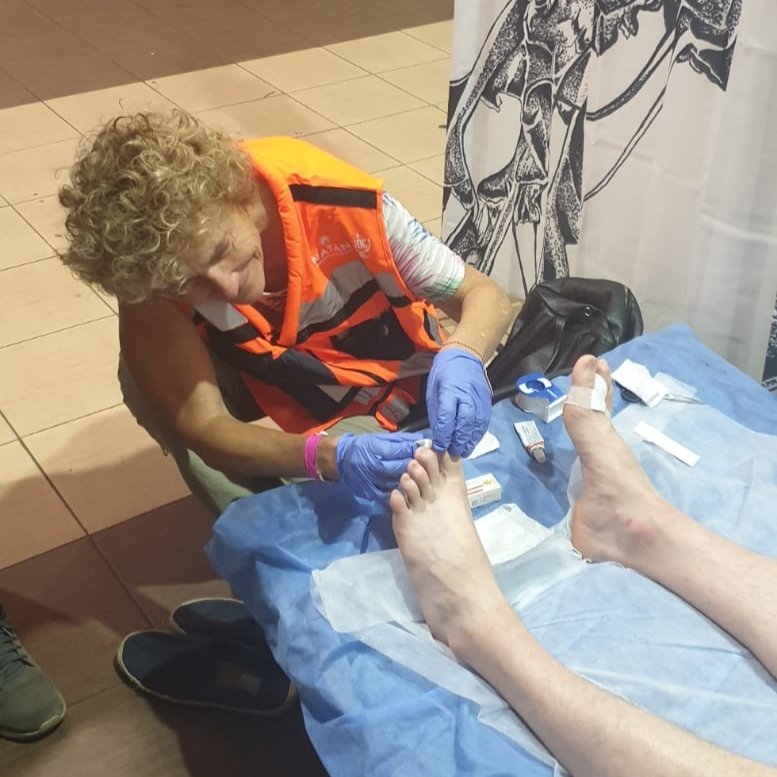 NATAN RN Genia Sternberg treats a refugee's foot wounds at the clinic in Przemysl Poland.