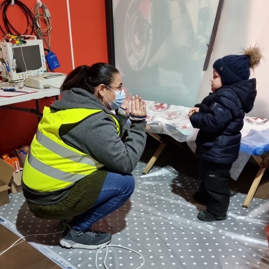 NATAN Social Worker Rada Rosler Davidov comforts a child at the refugee center clinic