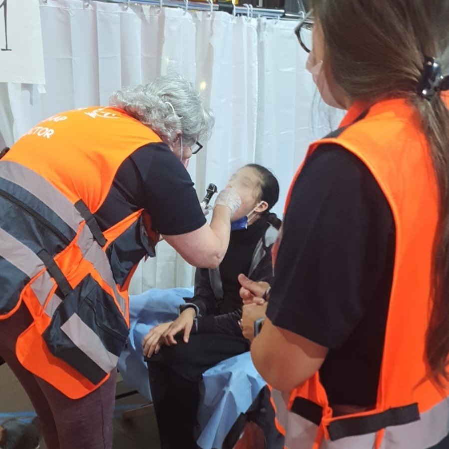 Social Worker Marina Kosenkova and Dr. Cristiane Isabela de Almeida with a patient at the clinic
