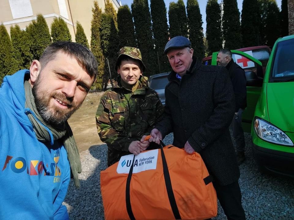 Folkowisko's Marcin Wodzirej Piotrowski receives bag of medical supplies from UJA Federation NY delegation