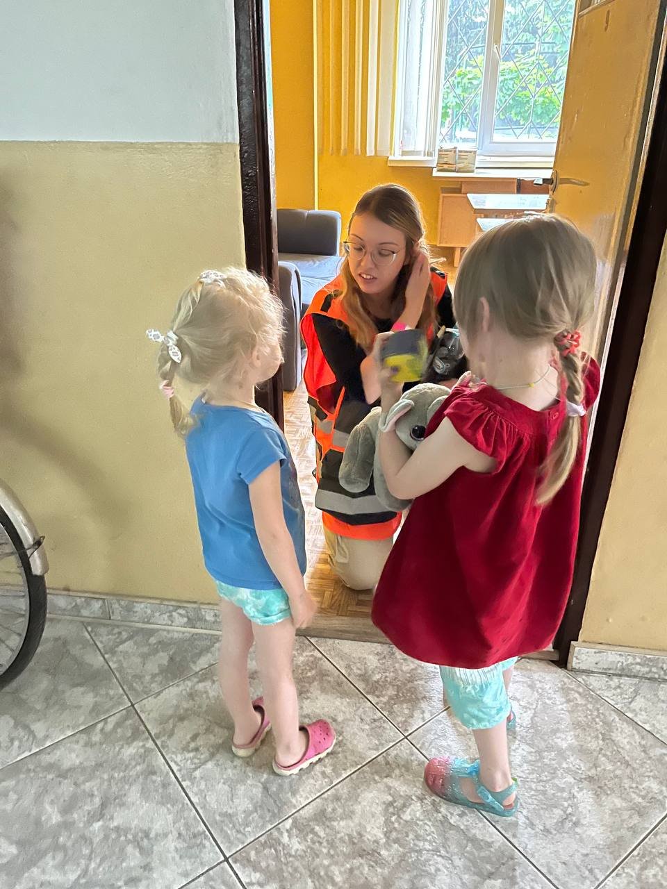 NATAN Social Worker Polina Rudkovsky interacts with two small children at a refugee center near Przemysl, Poland