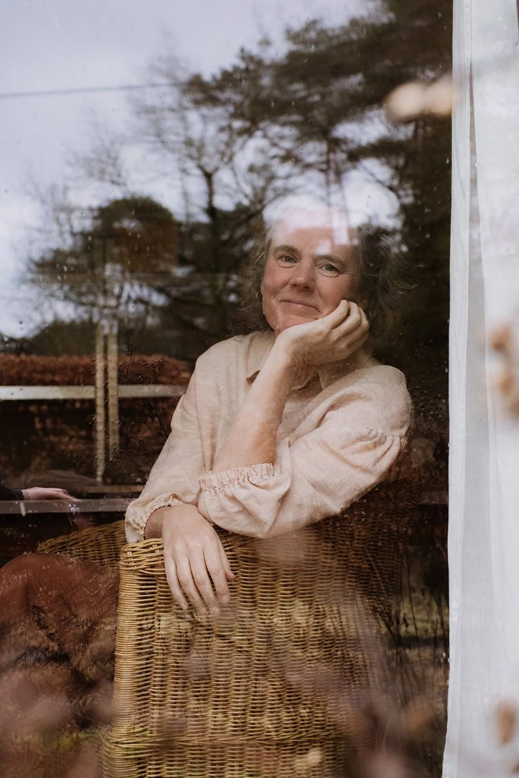 portretfoto van een vrouw die uit het raam kijkt