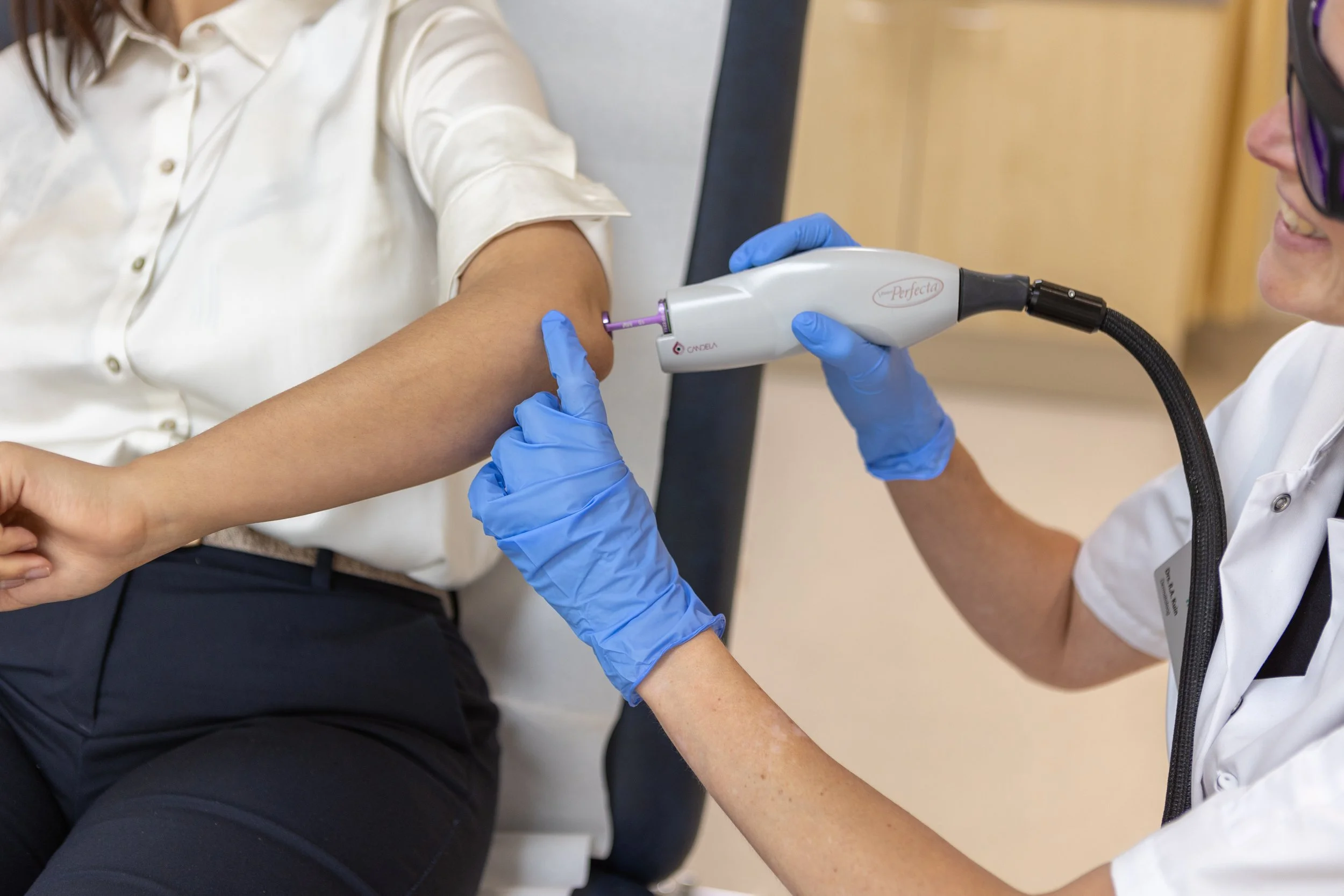 Een medische professional voert een intraveneuze behandeling uit op de arm van een patiënt in een kliniek.