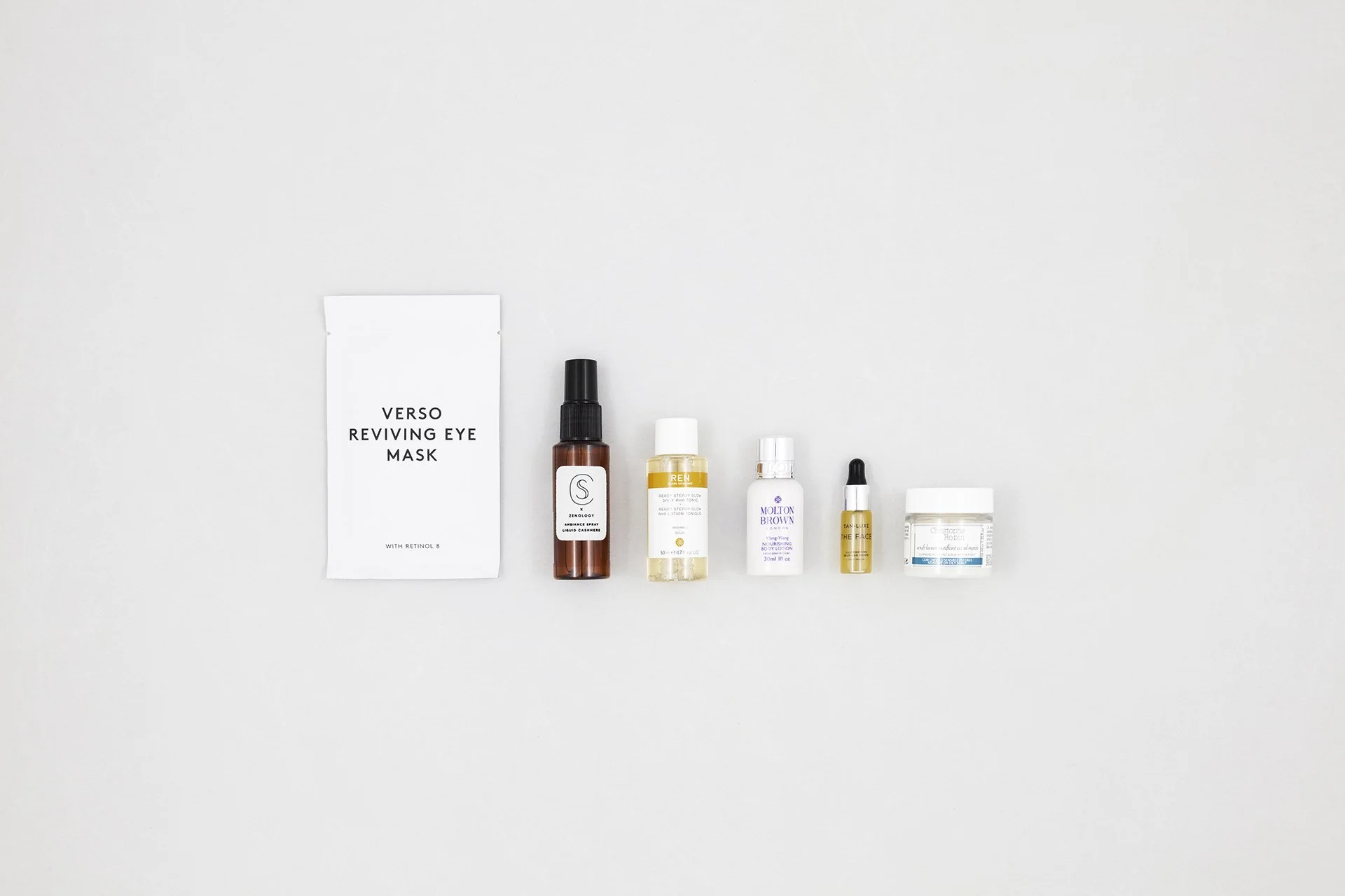 Verschillende skincare producten en een gezichtsmasker op een witte achtergrond.