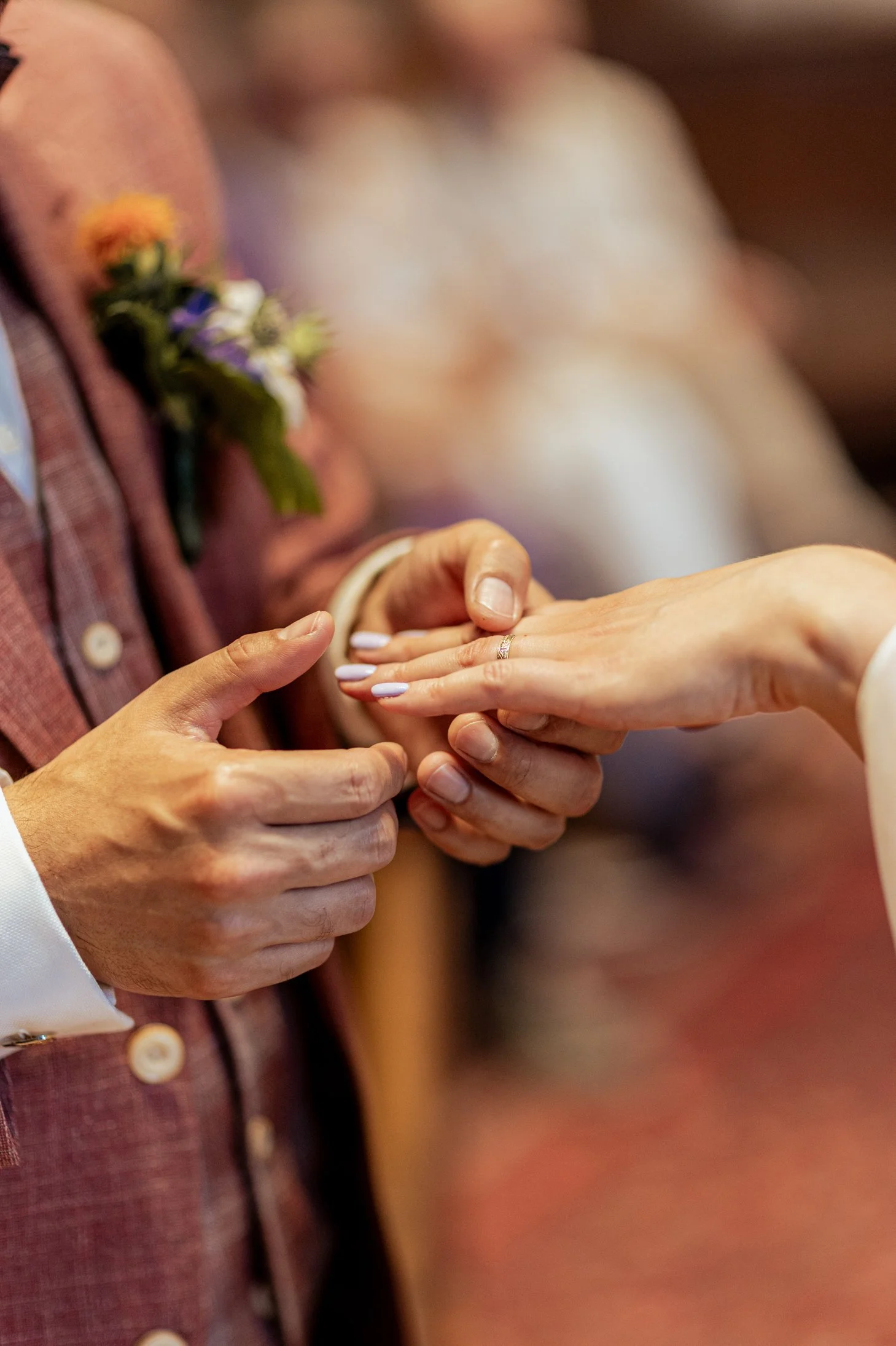 Een bruid die haar trouwring krijgt van haar partner tijdens een huwelijksceremonie.