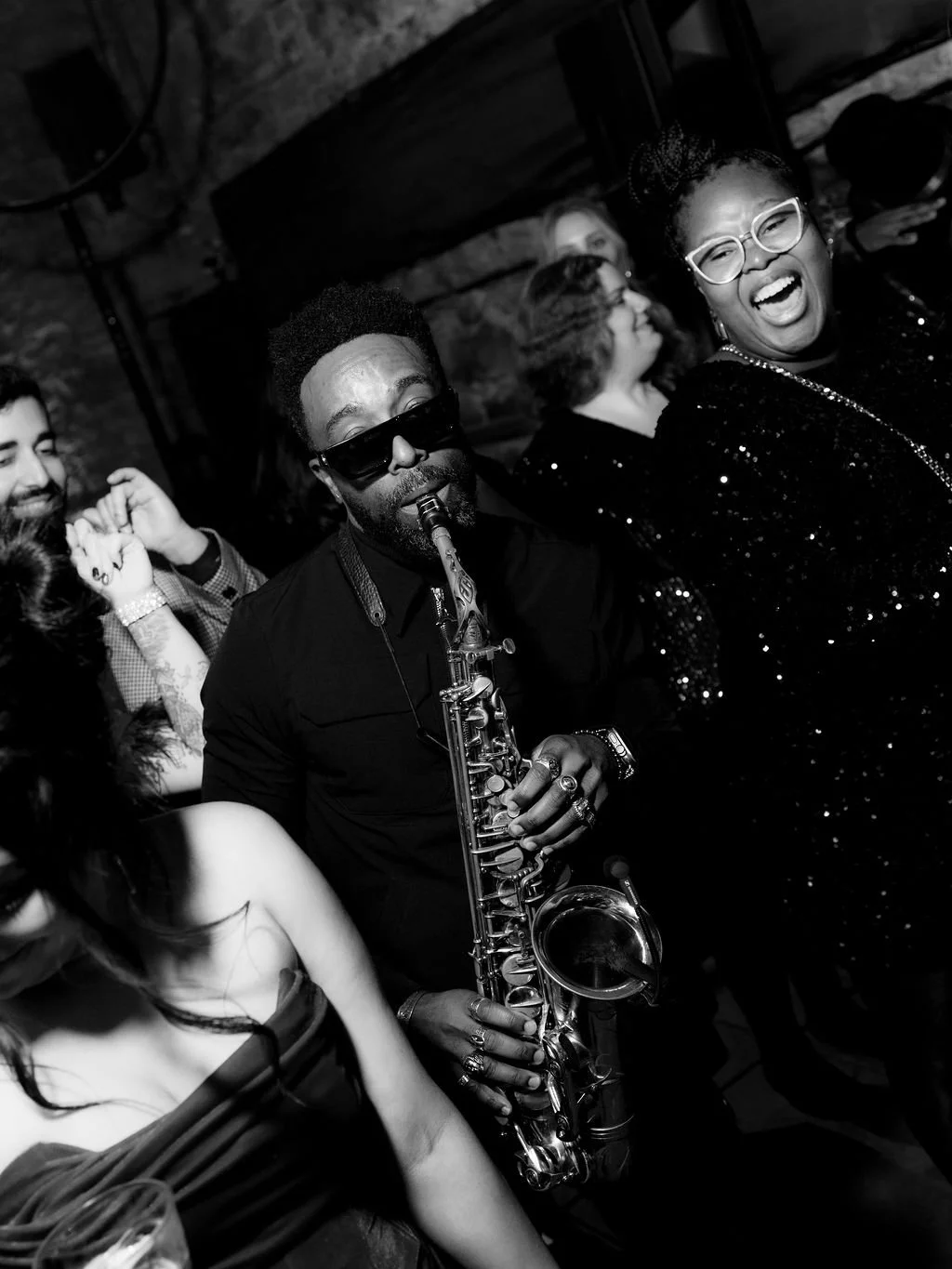 People dancing and enjoying live music at a party with a saxophonist in Edinburgh 