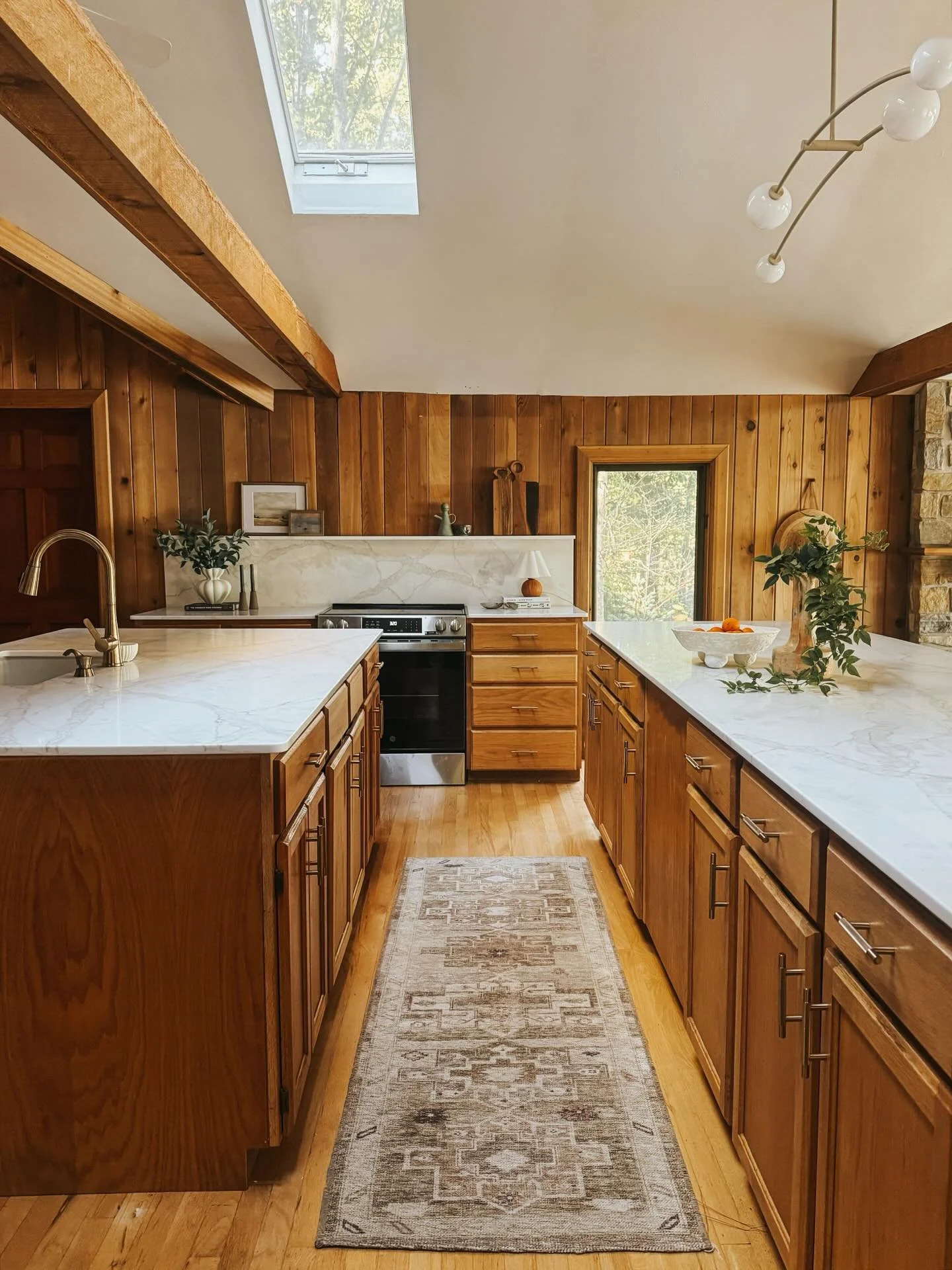 The kitchen and living at #otiscowoodscabin.

This was an entire kitchen reconfiguration complete with new appliances, gorgeous low profile quartz counters, and modern lighting. All new furniture, and stunning drapery spanning panoramic lake view win