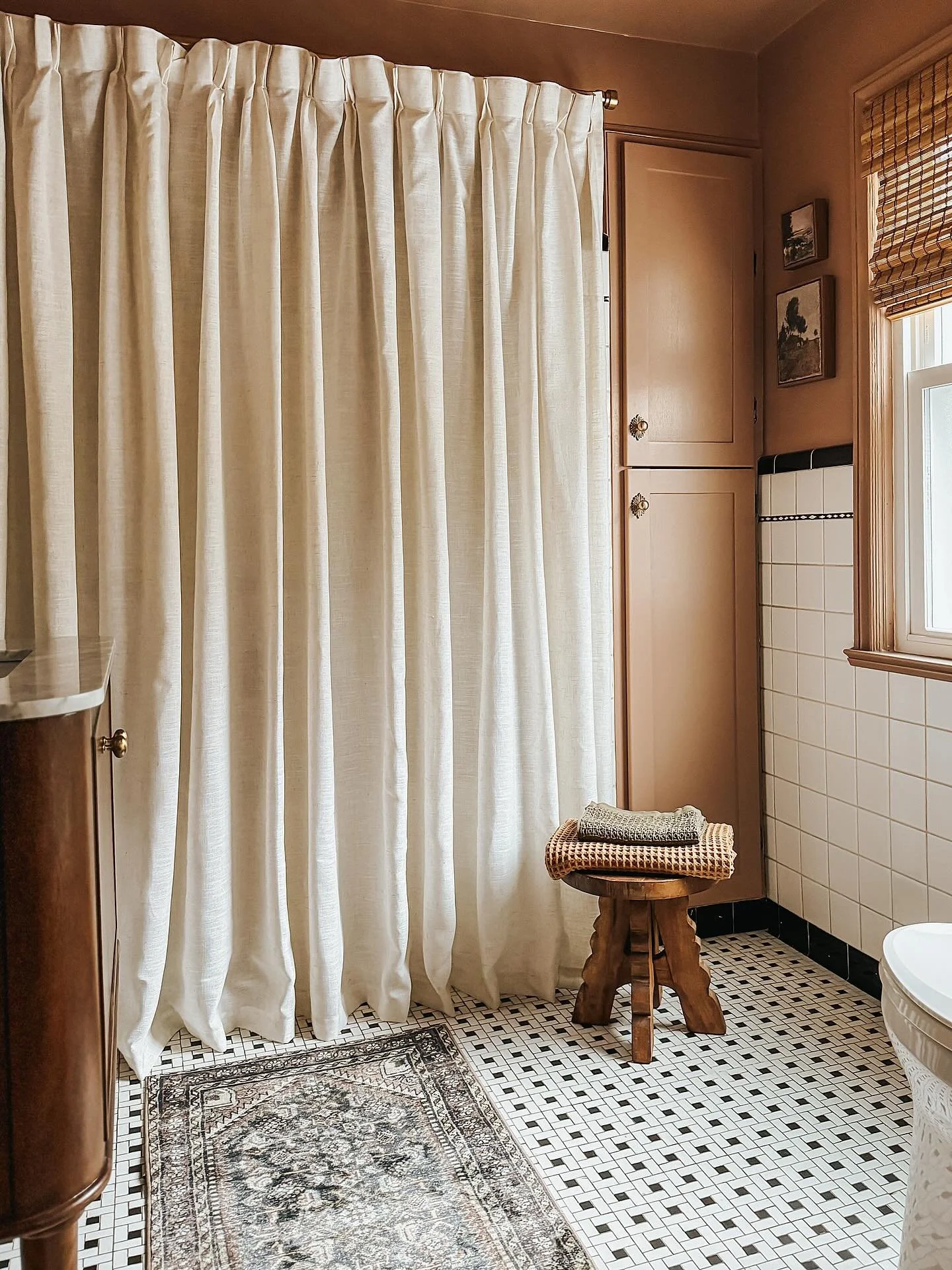 A no demo reno for a bathroom full of warmth and character. 

New marble top vanity, a moody brown blush color drench, updated cabinet fronts with decorative brass hardware, styling accessories that bring layers of heritage, and a dramatic linen curt