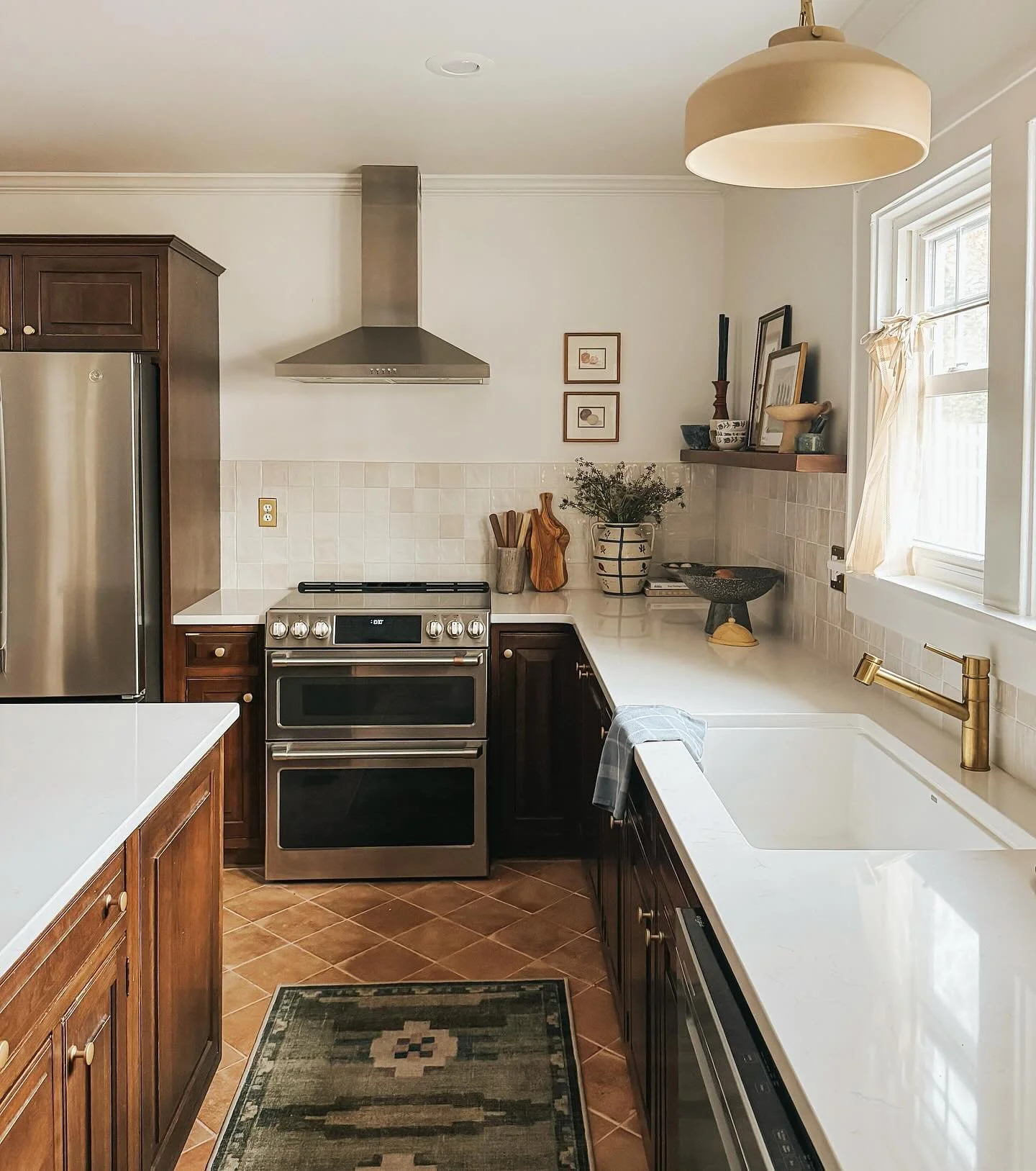 The kitchen at #dewittamericana.

Kept the lower cabinets but got rid of the uppers. New terracotta floors, zellige tile backsplash, quartz counters, open shelving, and a statement pendent over the sink for a whole new vibe in this cozy and collected