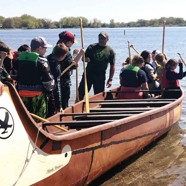  Photo of a big group of kids getting into the voyageur canoe with Anoka County Parks staff.  