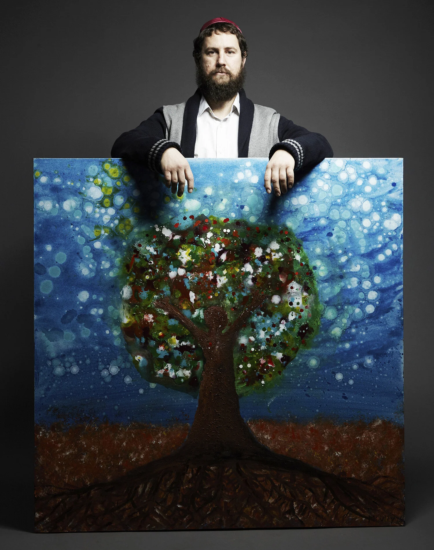Yitzchok Moully in his studio surrounded by colorful artwork