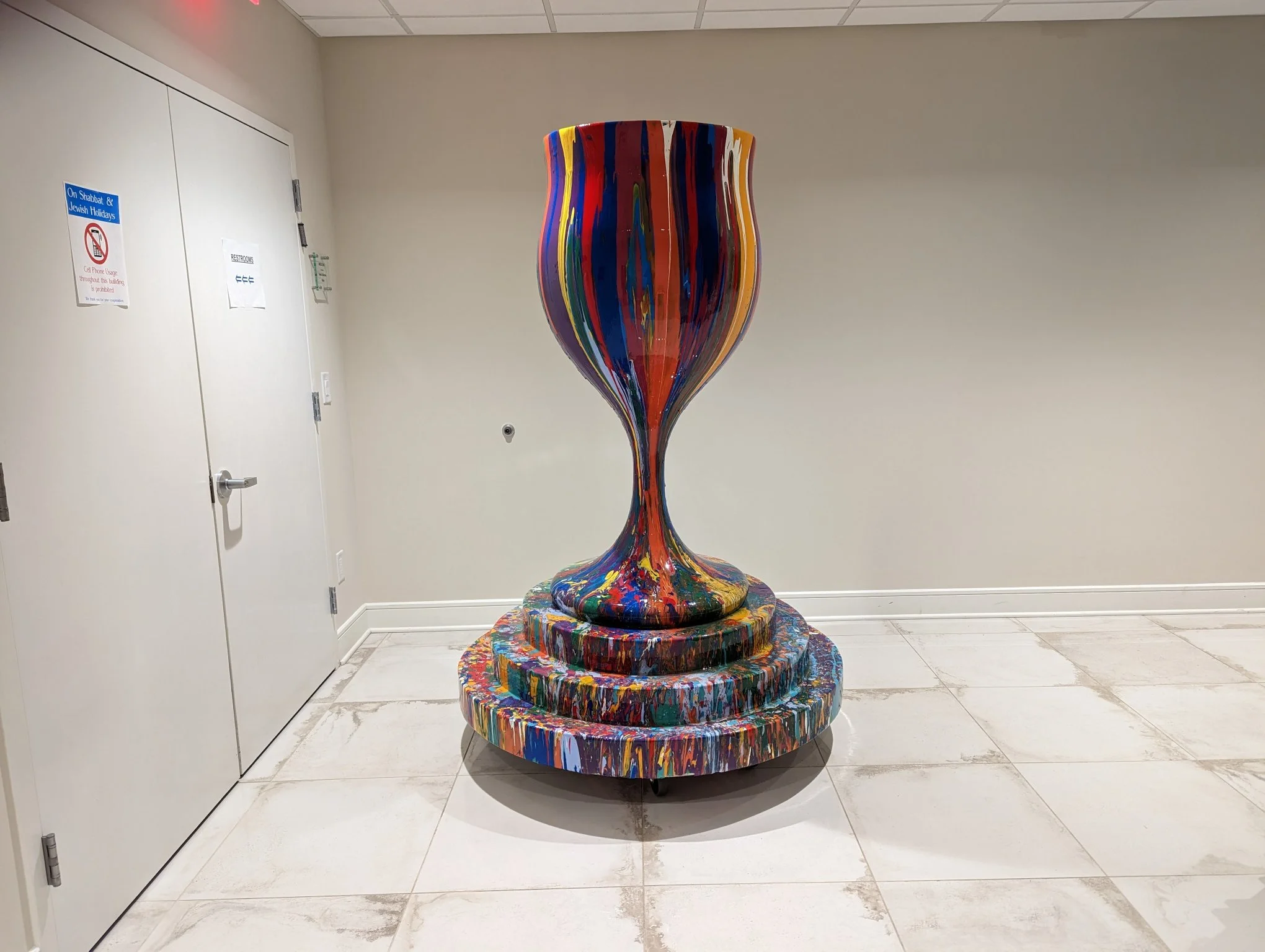 Overflowing Blessings wine glass sculpture by Yitzchok Moully — large multicolored drip-paint Jewish Judaica art piece, indoor display
