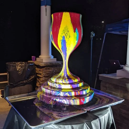 Colorful Chanukah menorah sculpture by Yitzchok Moully — tiered multicolored Jewish public art installation at evening event
