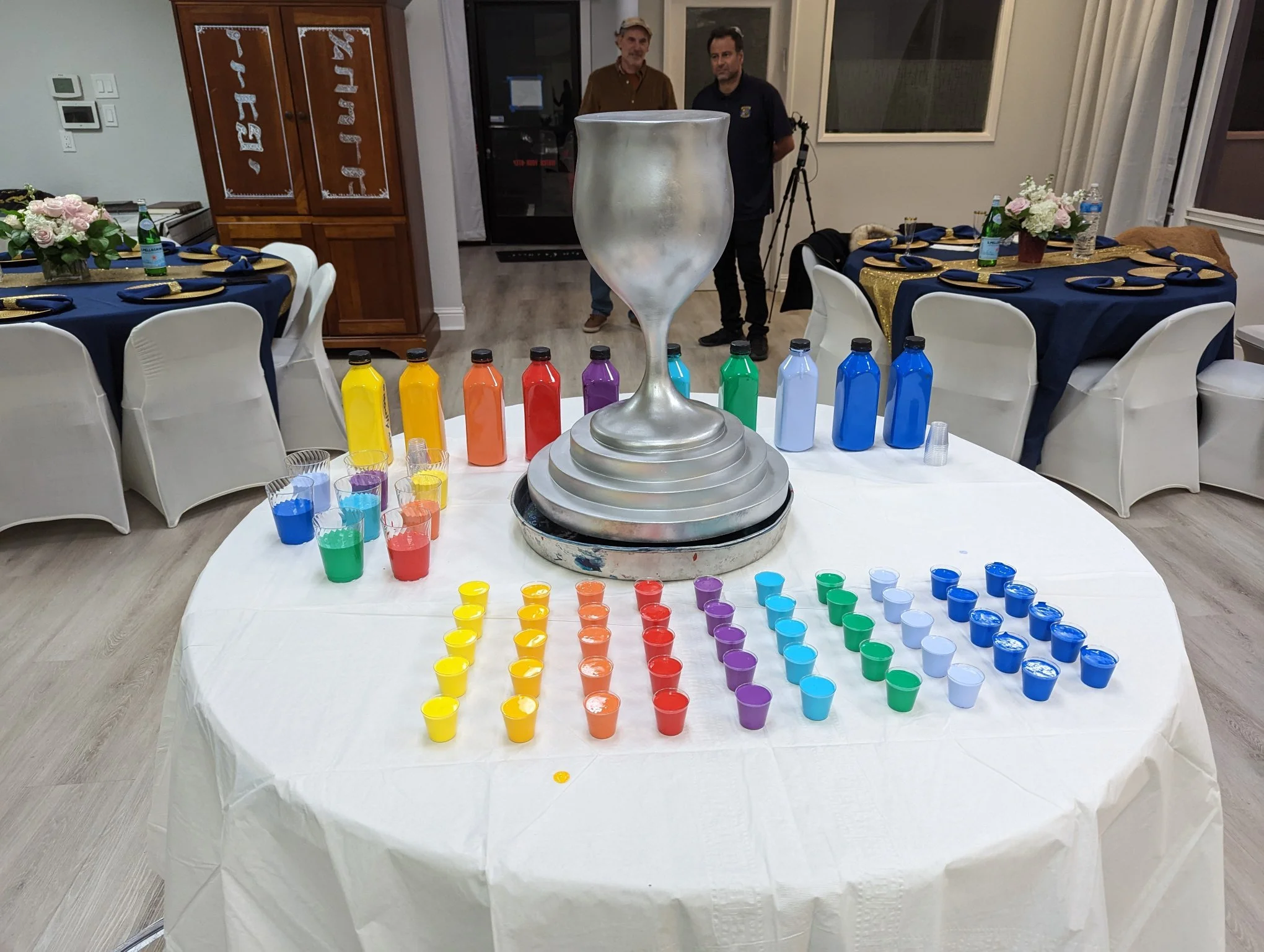 Yitzchok Moully’s interactive paint-pour activity setup at Jewish celebration event — colorful paint bottles on decorated party table