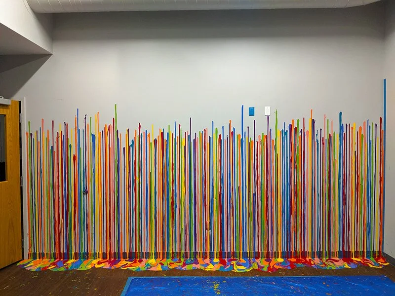 Colorful painted sticks on a wall and floor