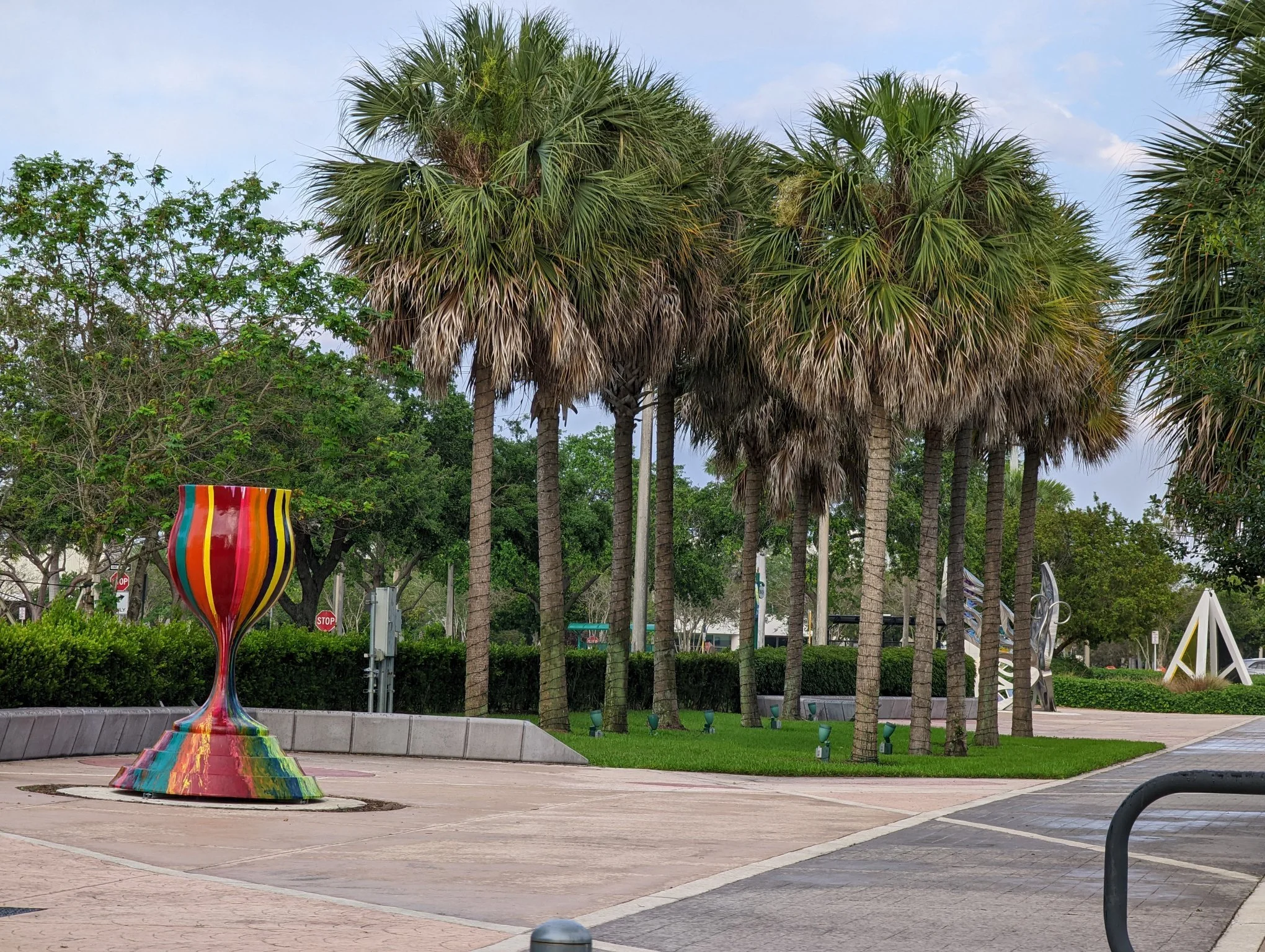 Tradition With a Twist public art menorah by Yitzchok Moully — colorful Jewish sculpture in outdoor park setting with palm trees, Florida