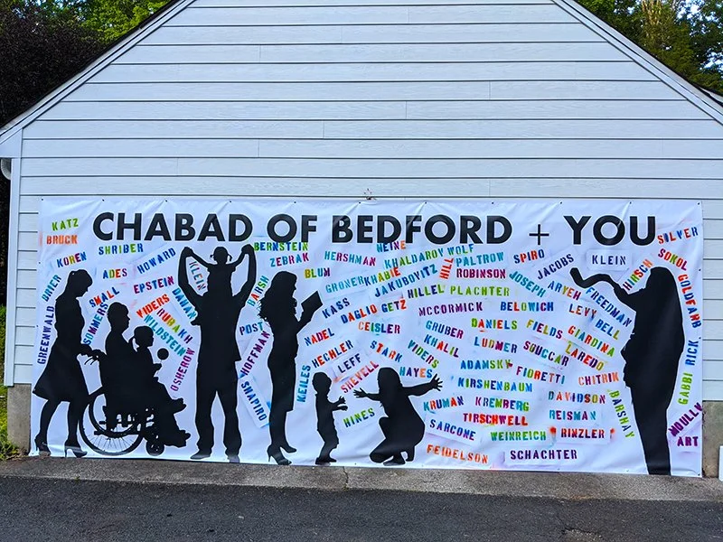 Large banner with the words 'Chabad of Bedford + You' at the top, featuring black silhouettes of people including a rabbi, children, and individuals in wheelchairs, surrounded by colorful names of various individuals.