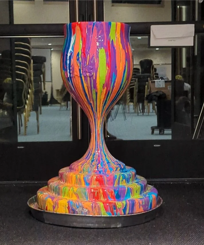 Overflowing Blessings kiddush cup sculpture by Yitzchok Moully — vibrant striped Jewish Judaica art with multicolored drip paint design