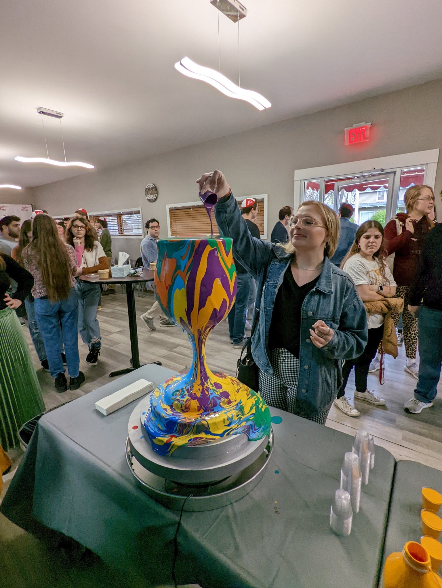 Participant pouring paint at Yitzchok Moully’s public art paint-pour workshop — interactive Jewish community art event