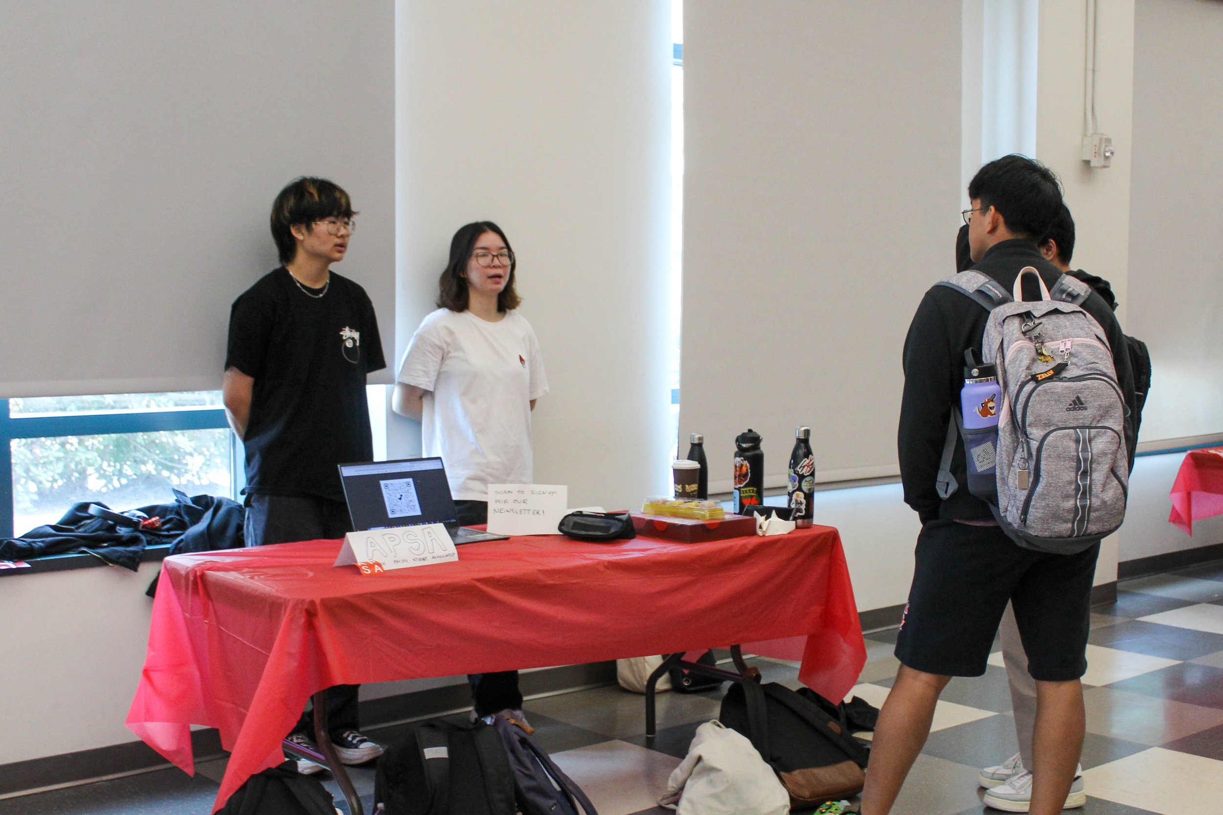    (From left) Sophomore Devon Tjong and junior Kaylin Li, both majoring in business administration, chat with attendees.   