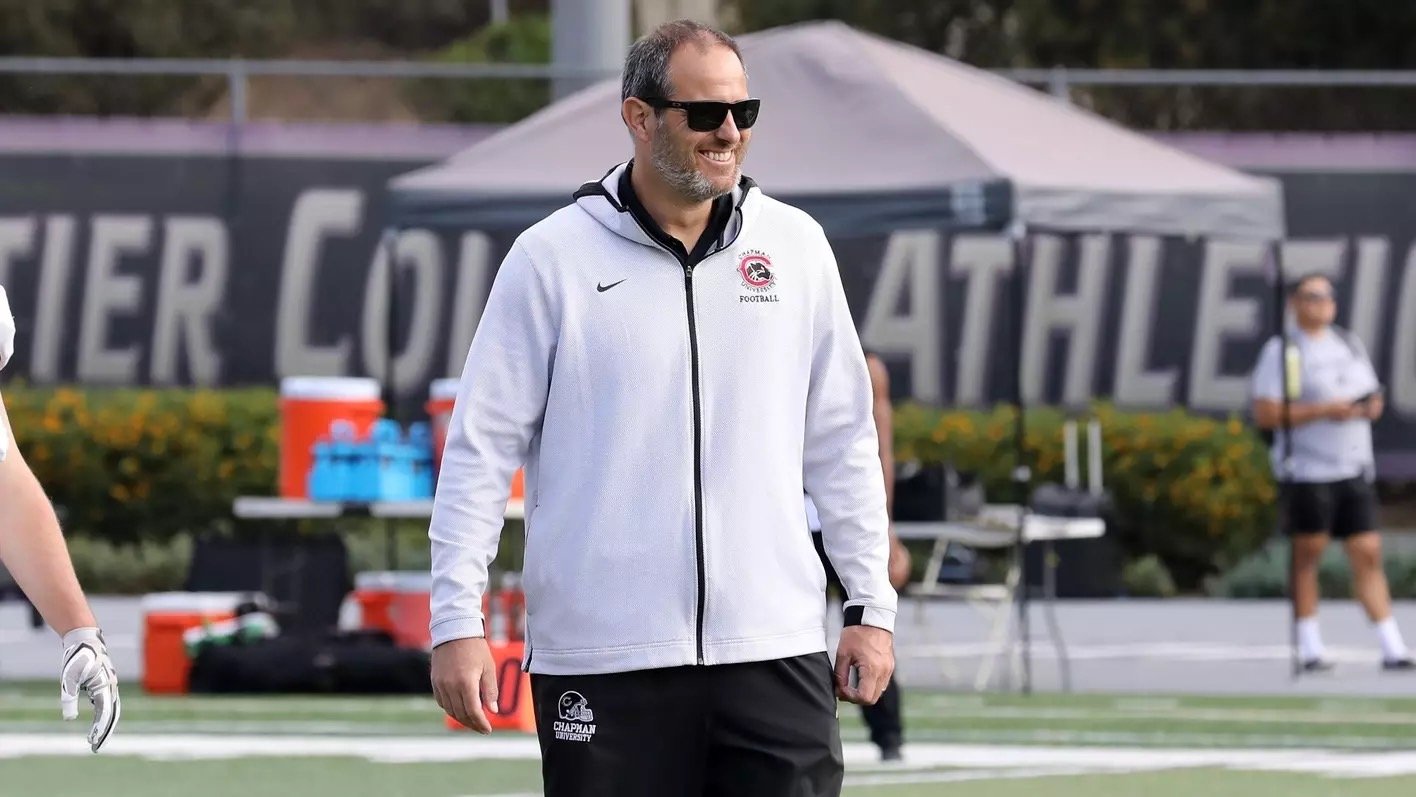 Chapman University football coach standing on the field during practice