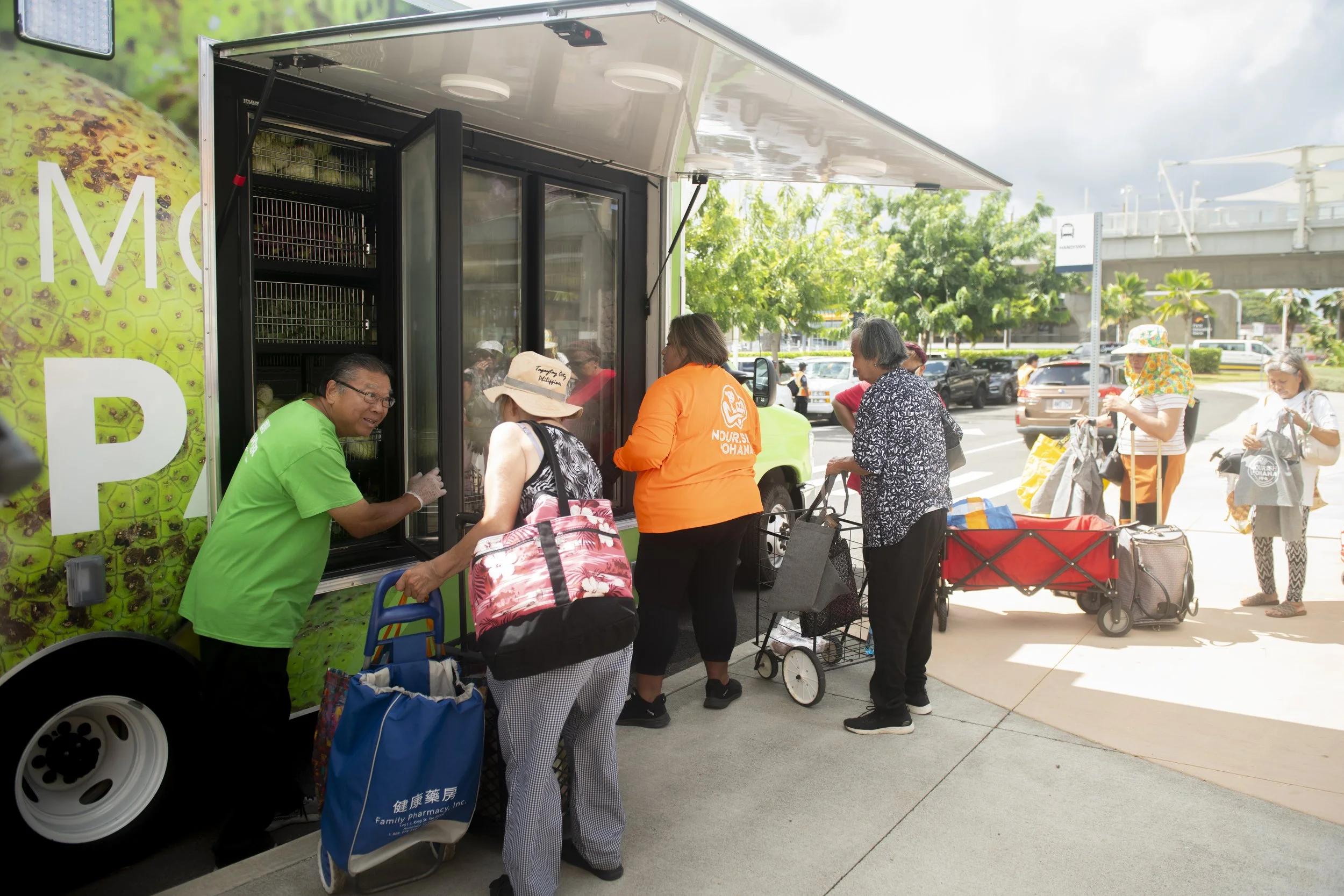 A mobile pantry set up at Skyline’s Hō‘ae‘ae Station with people receiving fresh vegetables.