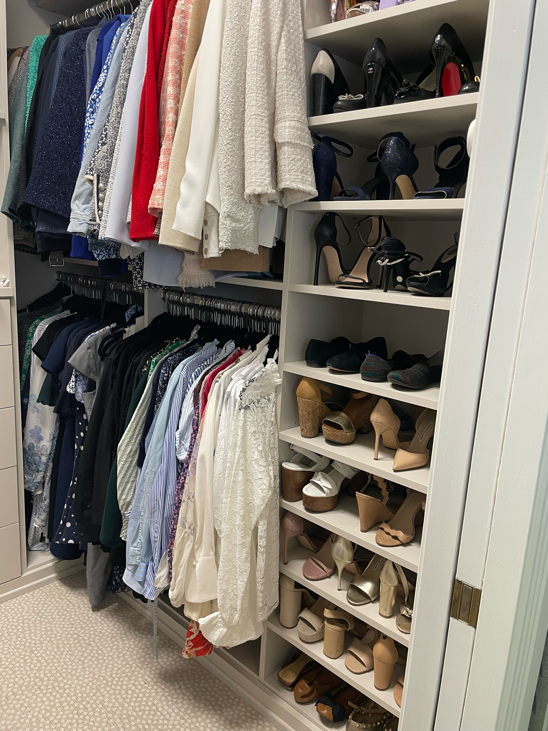 Image of an organized primary closet with clothing and shoes