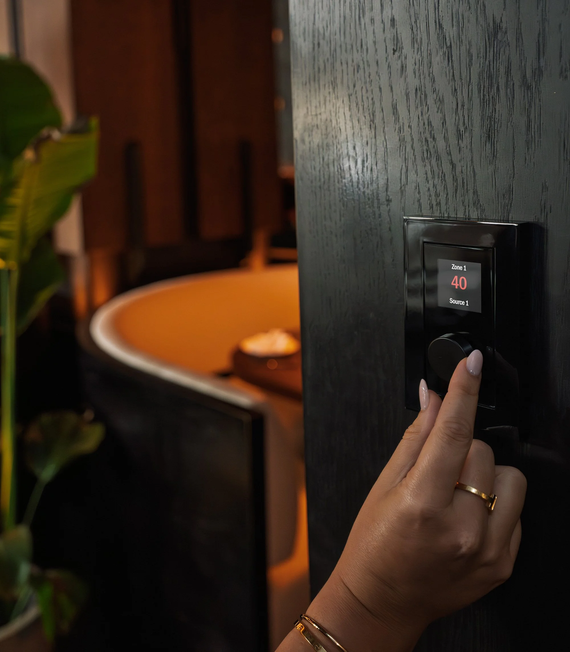 Close-up of an integrated smart wall keypad used to manage room temperature and audio, ensuring perfect comfort in a luxury residence.