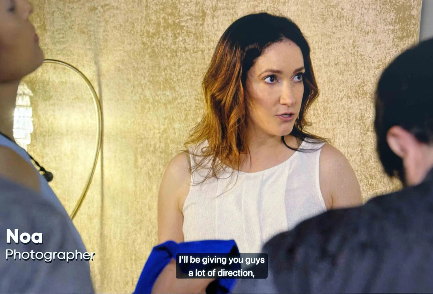 Noa Green directing on camera during the Lifetime TV shoot, on-screen caption reads Noa, Photographer