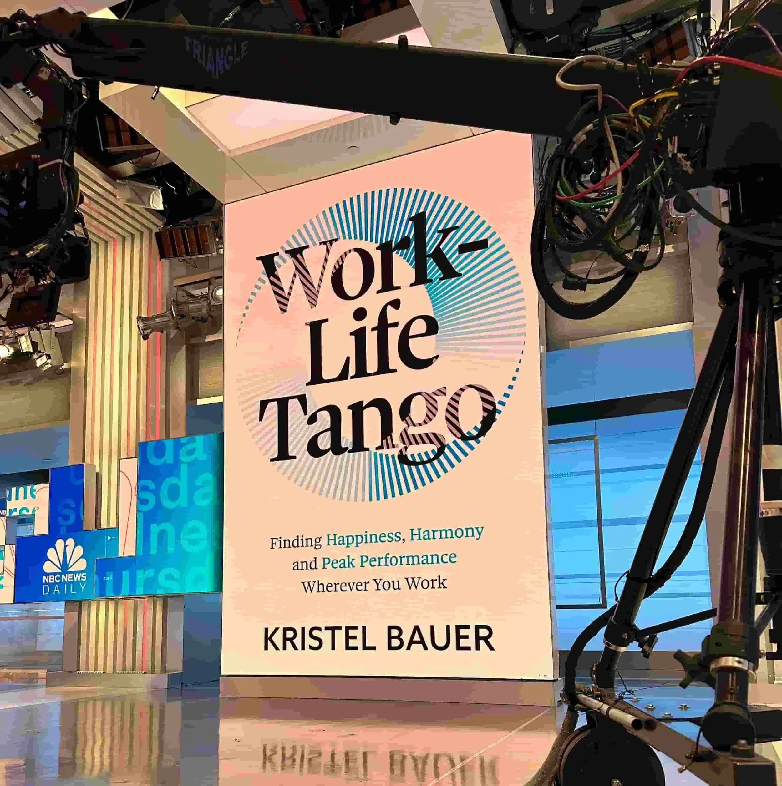 An enlarged photo of Kristel Bauer's book Work-Life Tango: Finding Happiness, Harmony and Peak Performance Wherever You Work inside a NBC News Daily TV studio