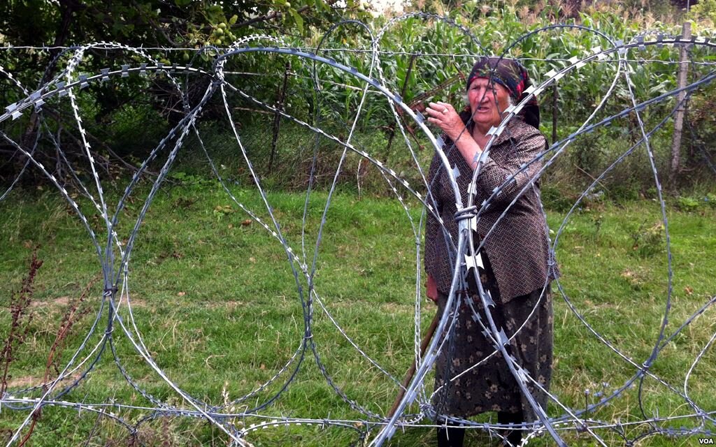 Georgian resident with barbed wire dividing their property along the informal South Ossetian border