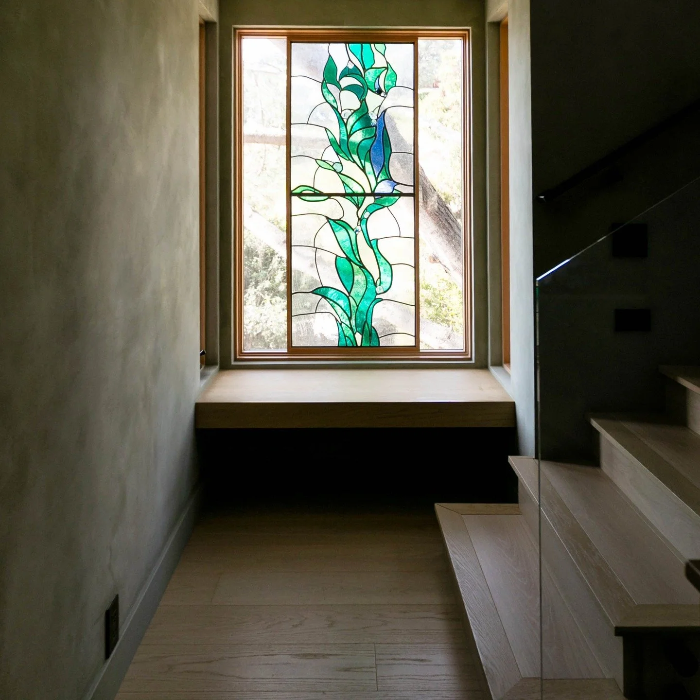 In this new four-story home, the stairwell plays a big role in day-to-day life. Wrapping the space in moody green lime plaster that resonates with the Torrey Pine tree outside and the James Hubbell stained glass inside provides continuity from level 