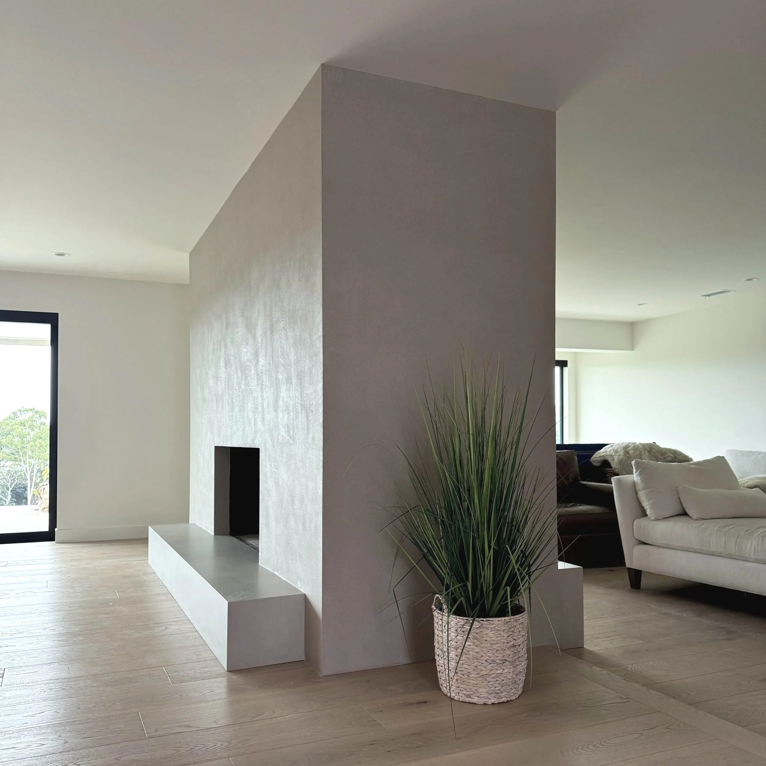 Modern minimalist double-sided fireplace with lime plaster