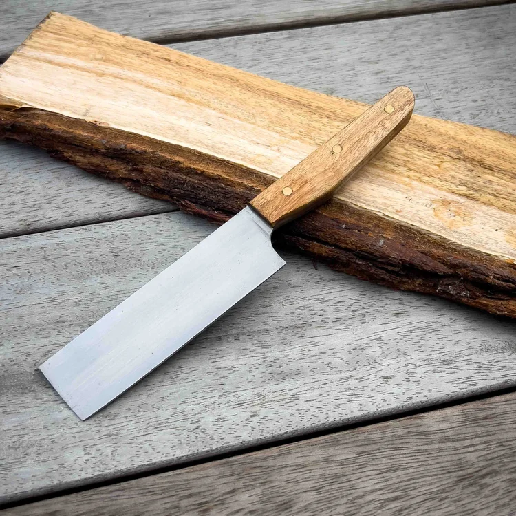 Handmade kitchen knife with a timber handle on a slab of wood