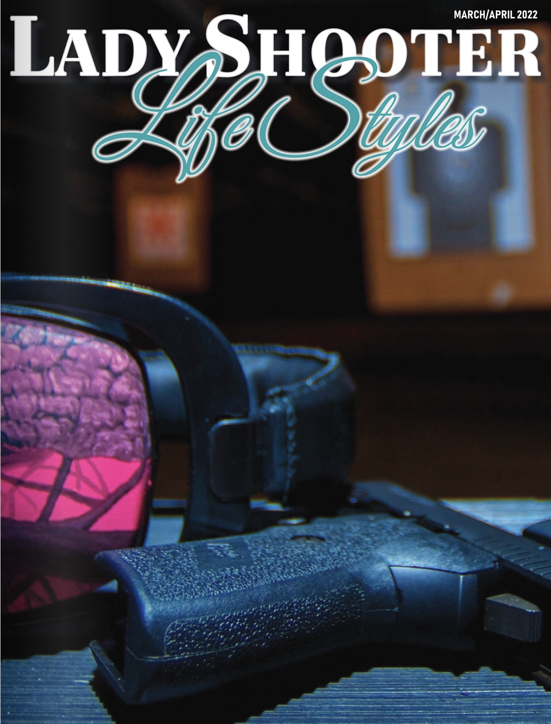 Close-up of a black handgun and a pink and black ski mask on a dark surface, with a blurred background featuring a wooden picture frame and a trophy. The magazine cover text reads 'Lady Shooter Life Styles' and indicates March/April 2022.