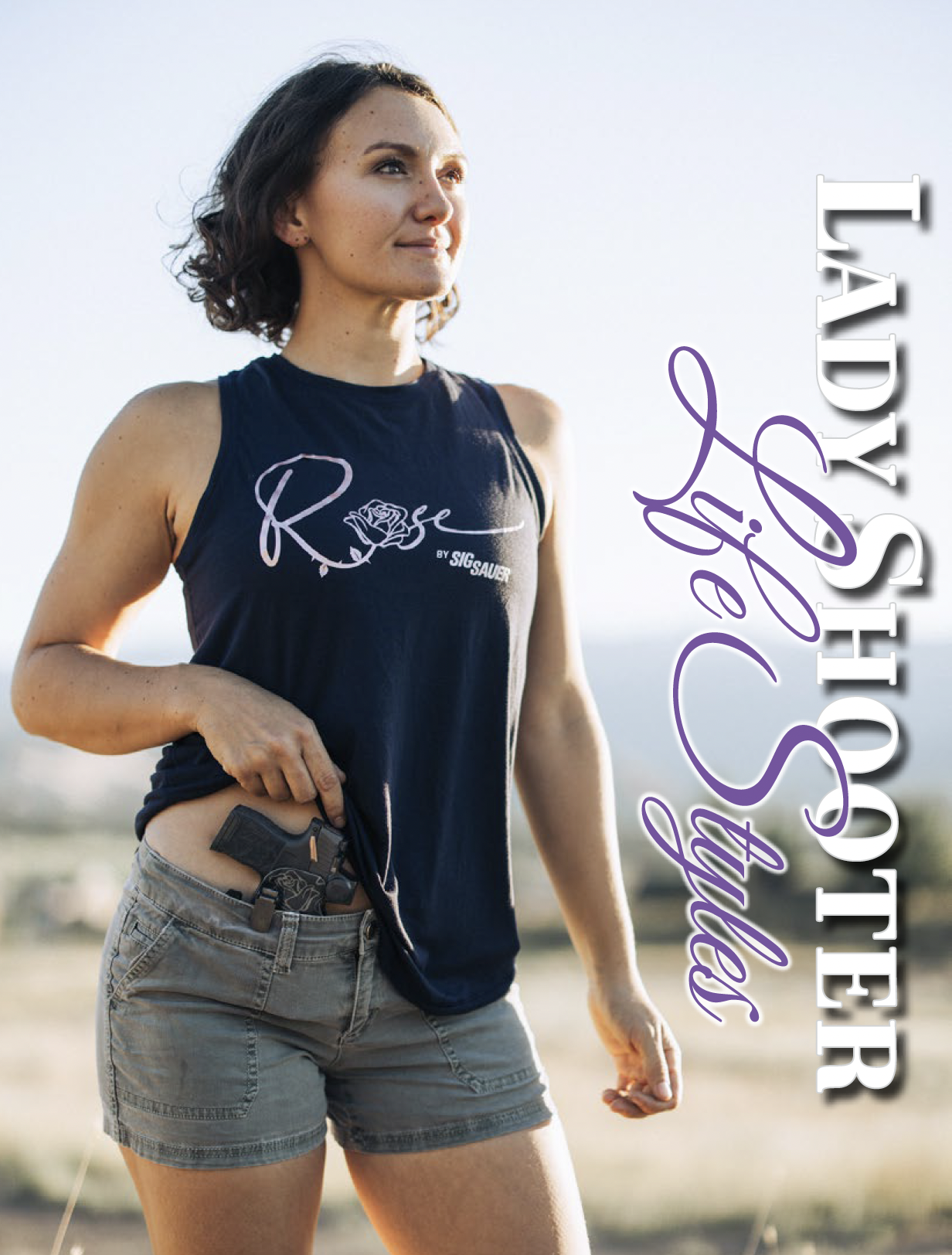 A young woman with short dark hair and light skin outdoors, wearing a navy tank top and khaki shorts, with a gun tucked into her waistband. The image includes text that reads, 'Ladyshootersher Life' written vertically.