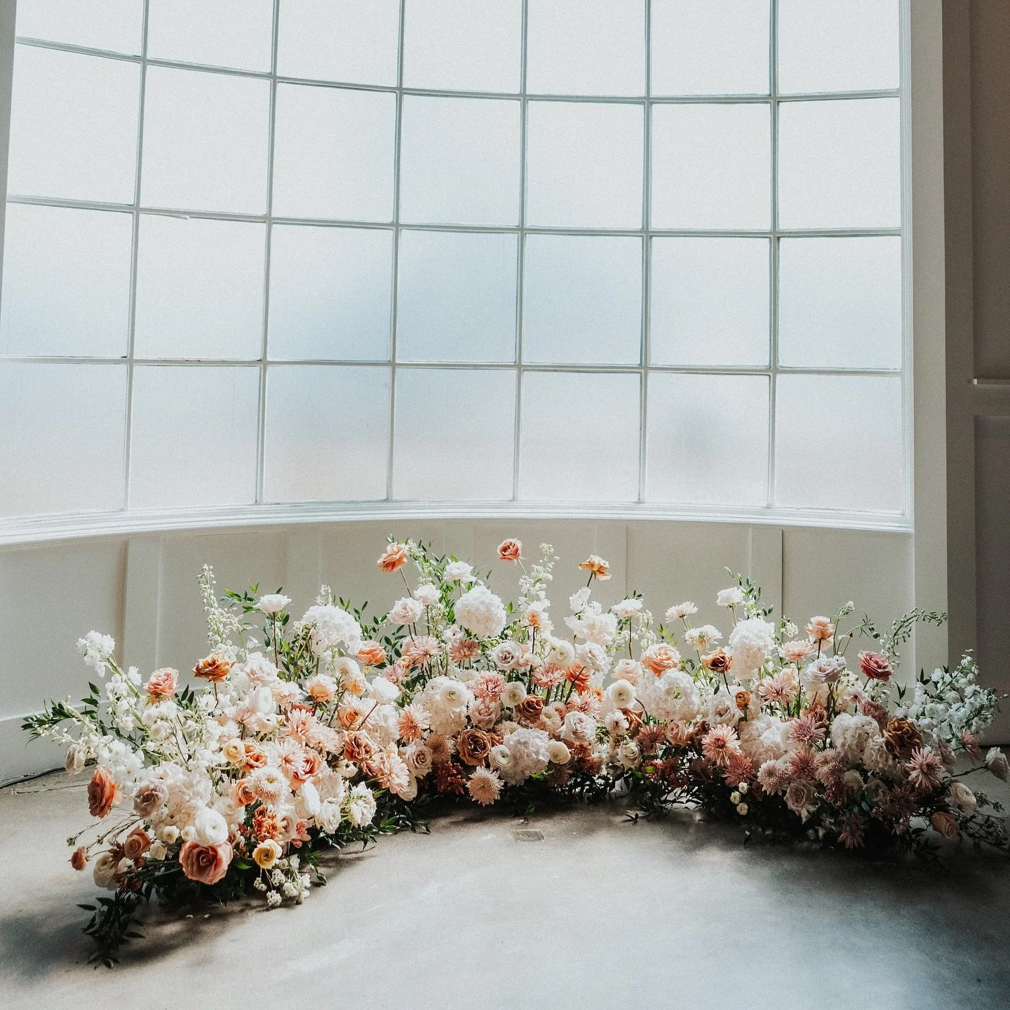✨ From &ldquo;I do&rdquo; to &ldquo;let&rsquo;s celebrate!&rdquo; ✨ We love repurposing ceremony flowers to reception spaces. This lush floor arch was designed to frame the vows and then brought inside to create a dreamy floral backdrop for the sweet
